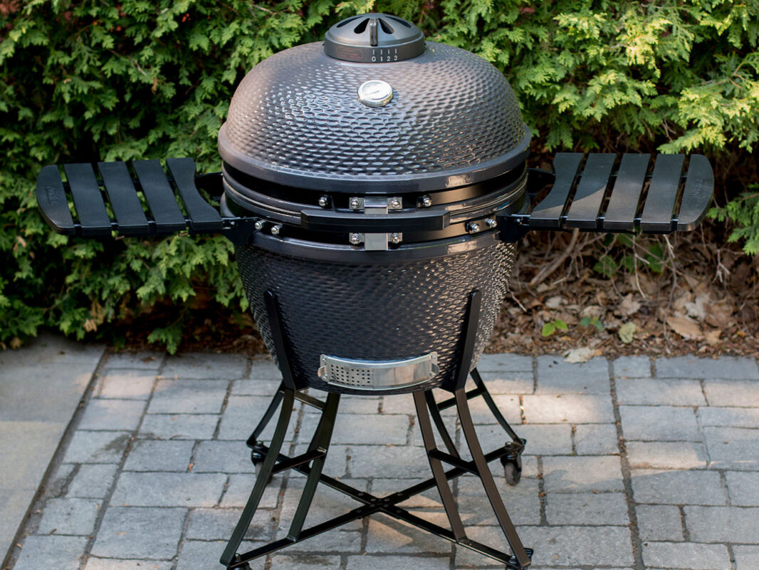 Kamado 25 with a green backdrop in a backyard patio.
